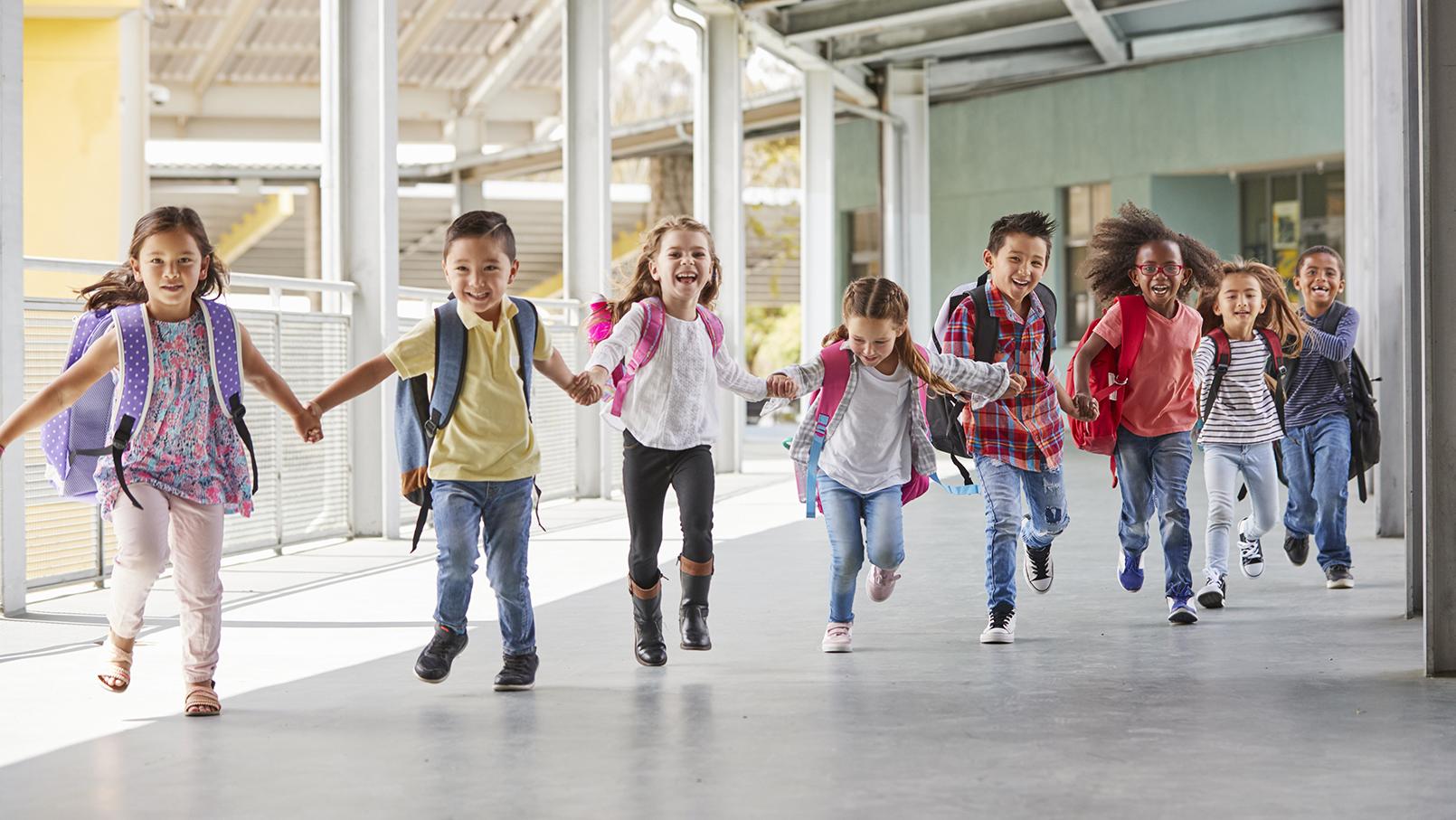 Elever kommer løpende mot fotografen