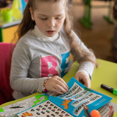 En jente i Ukraina ser på undervisningsmateriell levert av UNICEF
