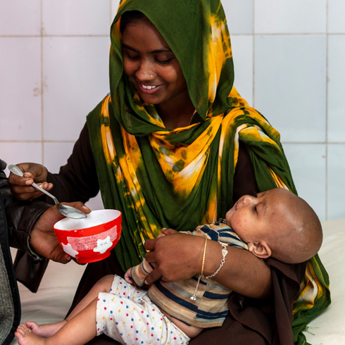 En kvinne gir terapeutisk melk til sin alvorlig underernærte sønn