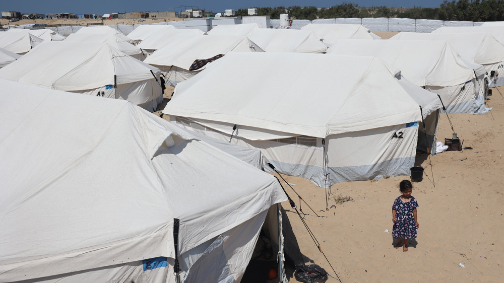 En liten jente utenfor en teltleir i Rafah, Gaza
