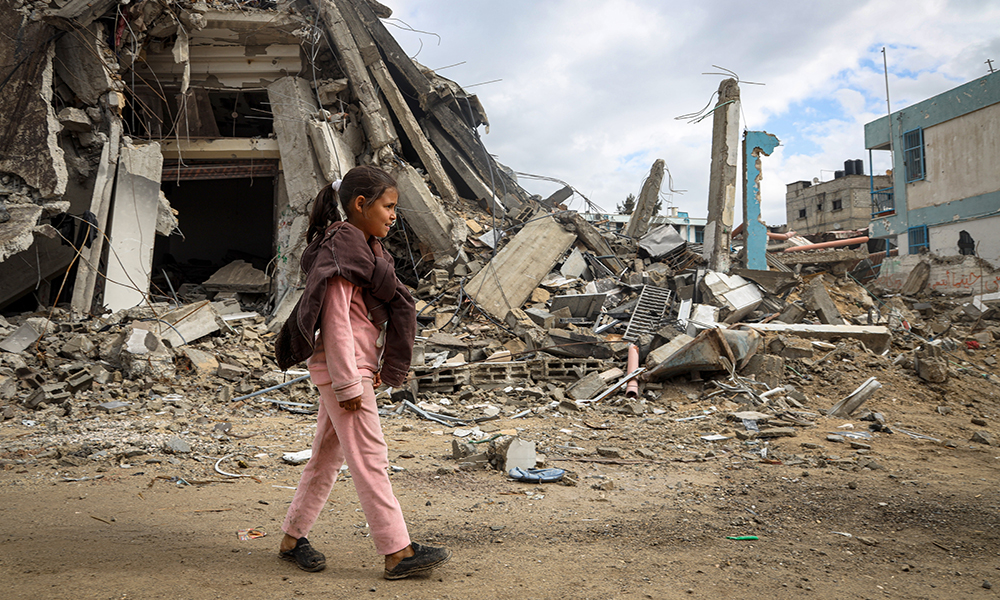 Jente foran bombede hus Gaza