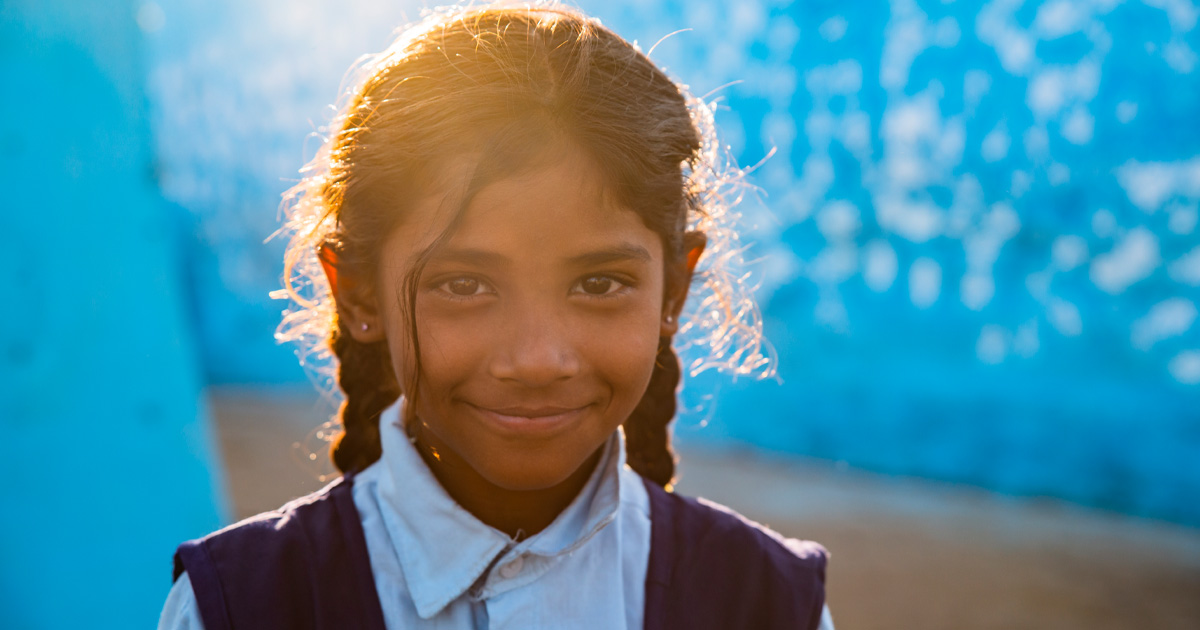 En jente står foran blå vegg