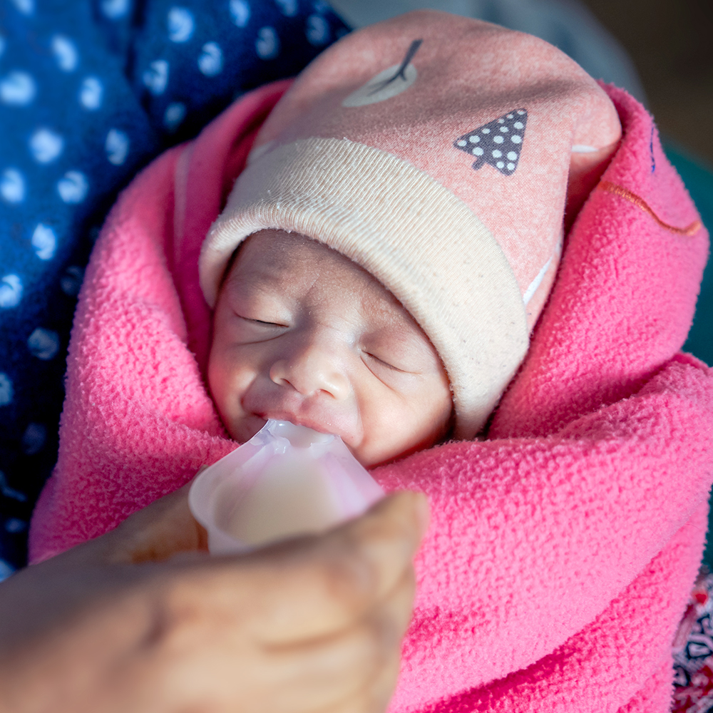 Et spedbarn får melk, Nepal