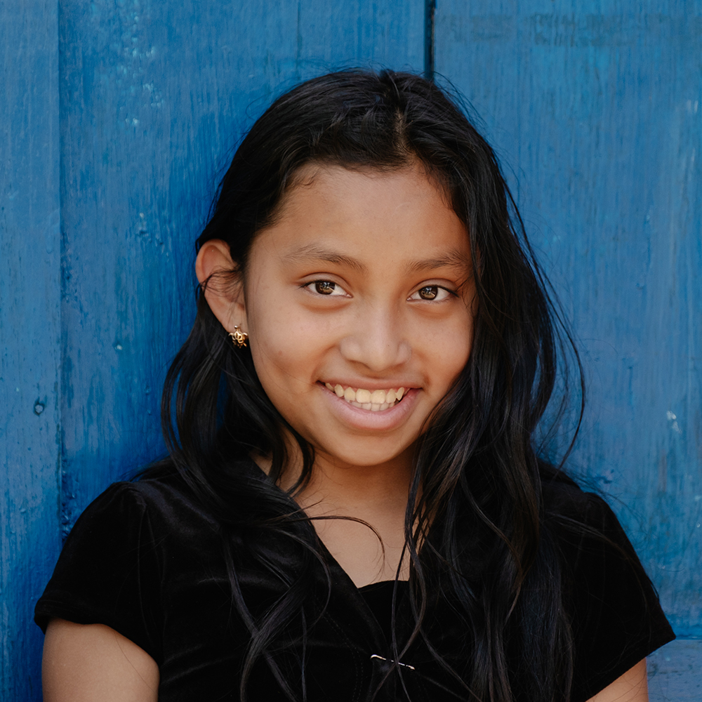 En jente smiler mot kamera, Guatemala