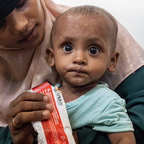 En mor gir barnet sitt terapeutisk nødmat, Bangladesh