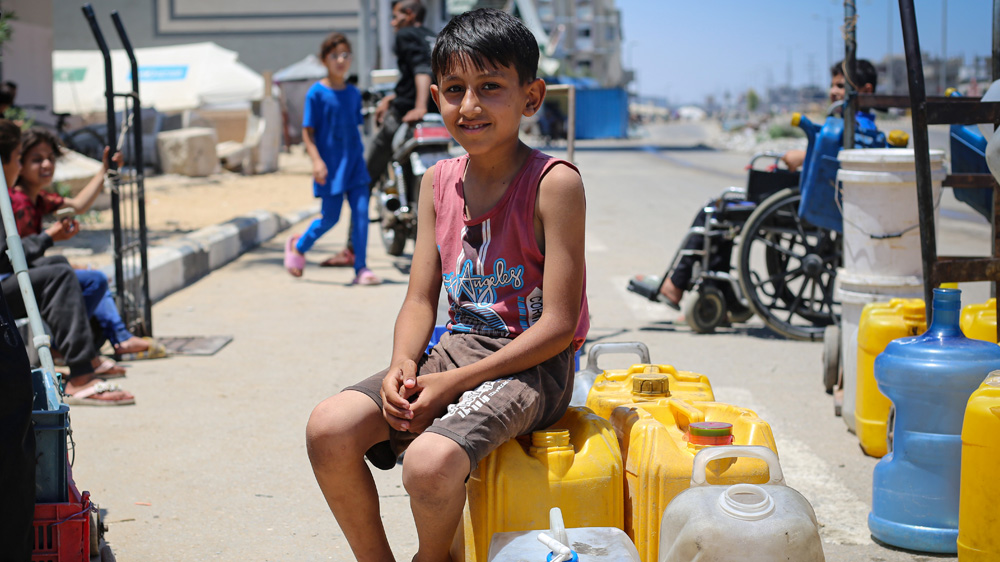 En gutt sitter på vannkanner, Gaza