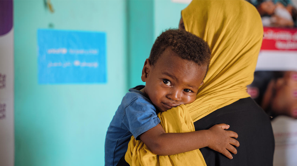 Lite barn hviler på en voksen skulder