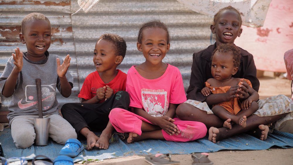 Barn leker utenfor det midlertidige hjemmet sitt, Sudan