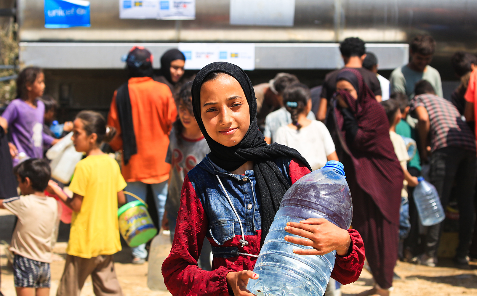 Jente fra Gaza bærer rent vann. FOTO