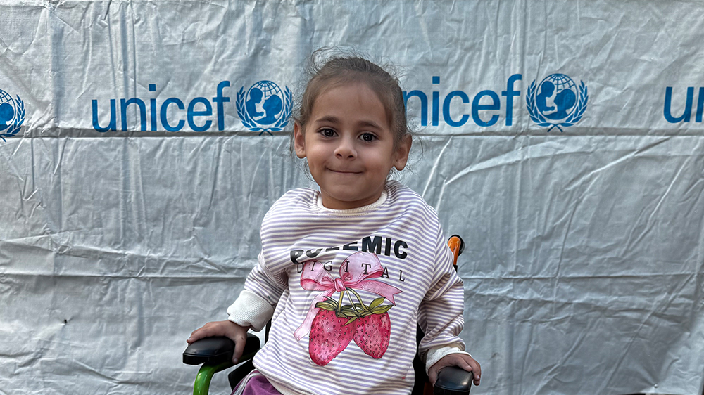 Jente i rullestol smiler, Gaza. FOTO