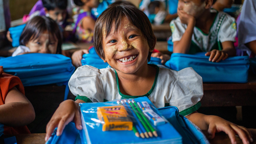 San (6) smiler etter å ha mottatt nye skolesaker fra UNICEF, Myanmar