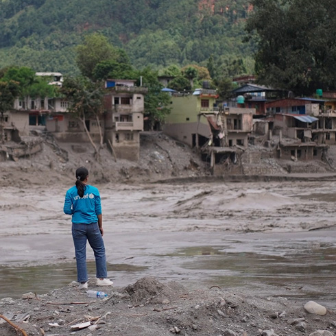 En UNICEF-ansatt ser ut over ødeleggelsene etter flommen i Nepal