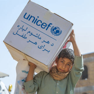 En gutt bærer en eske med hygieneprodukter fra UNICEF, Afghanistan