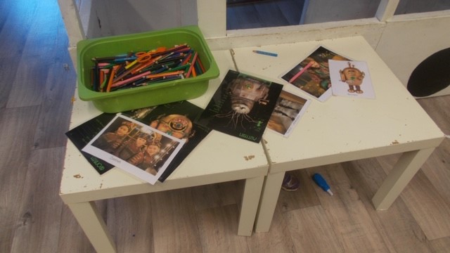 Bilde av diverse tegnesaker på et bord sammen med printede bilder fra en tv-serie.