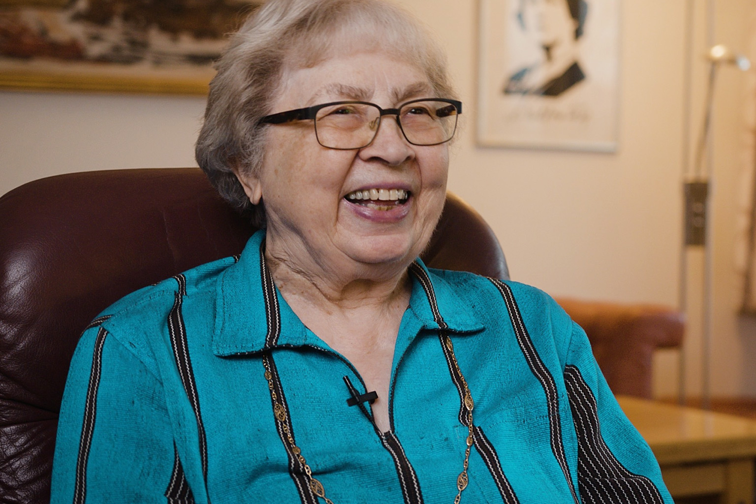 En eldre kvinne sitter i en stol