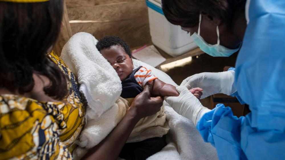 UNICEF-sykepleier vaksinerer et spedbarn