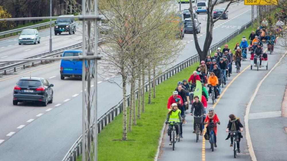 Bilde av gruppe syklister ved siden av biltrafikk.
