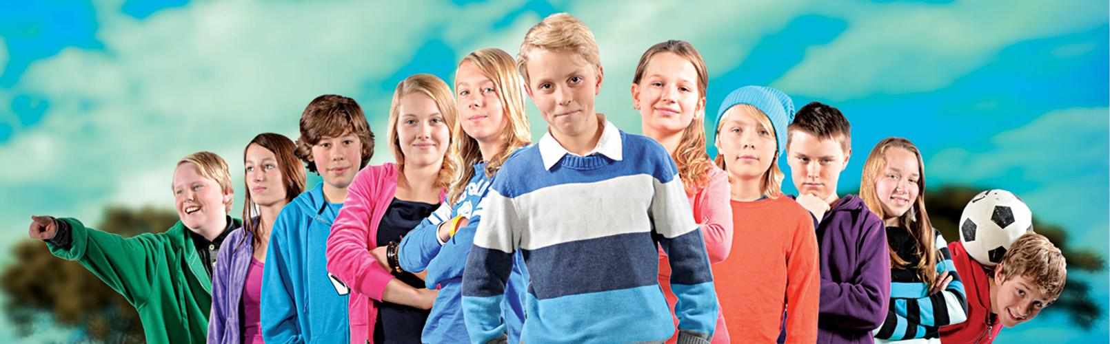 Barn på rekke ser mot kamera