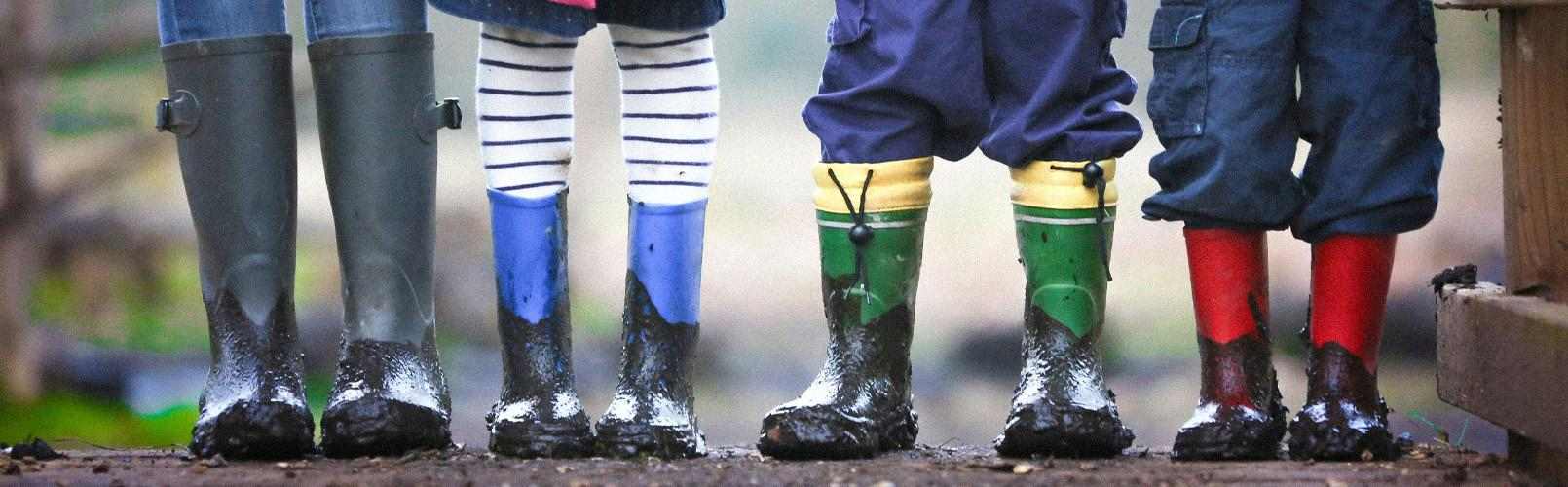 Nærbilde av bena og føttene til mange barn som står ved side av hverandre