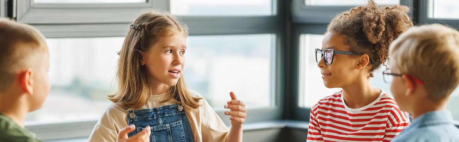 Barn sitter i gruppe og diskuterer