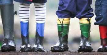 Nærbilde av bena og føttene til mange barn som står ved side av hverandre