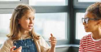 Barn sitter i gruppe og diskuterer