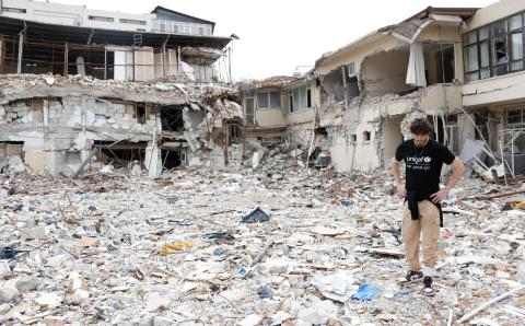 En UNICEF-ansatt går blant ruiner i Tyrkia etter jordskjelvene i februar 2023