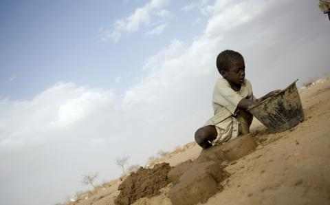 Gutt i Sudan graver i sand