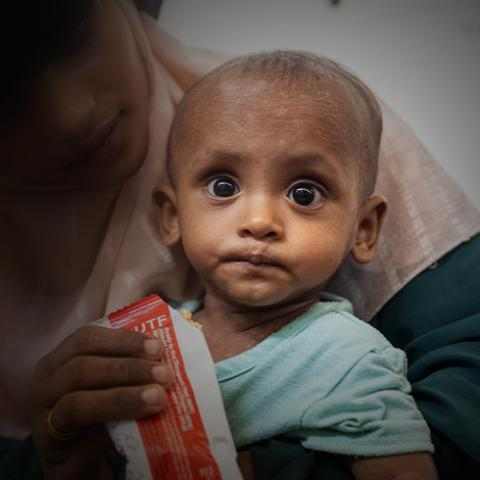 En mor gir sitt underernærte barn nødmat, Bangladesh