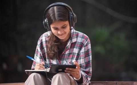 Jente med øreklokker og mobil