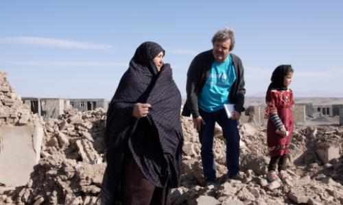 UNICEF-ansatt sammen med 8 år gamle Adina og hennes mor blant ruinene der hjemmet deres sto