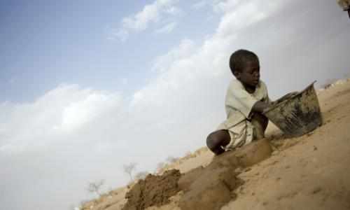 Gutt i Sudan graver i sand