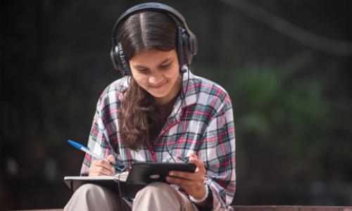 Jente med øreklokker og mobil