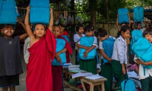 En skoleklasse viser frem de nye skolesekkene de har fått fra UNICEF, Myanmar