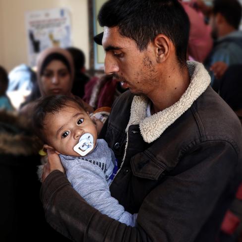 En far holder barnet sitt, Gaza