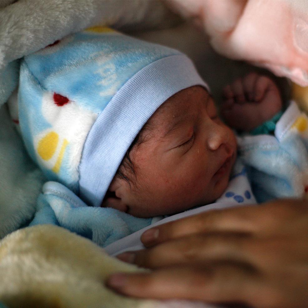 Nyfødt baby og voksen hånd