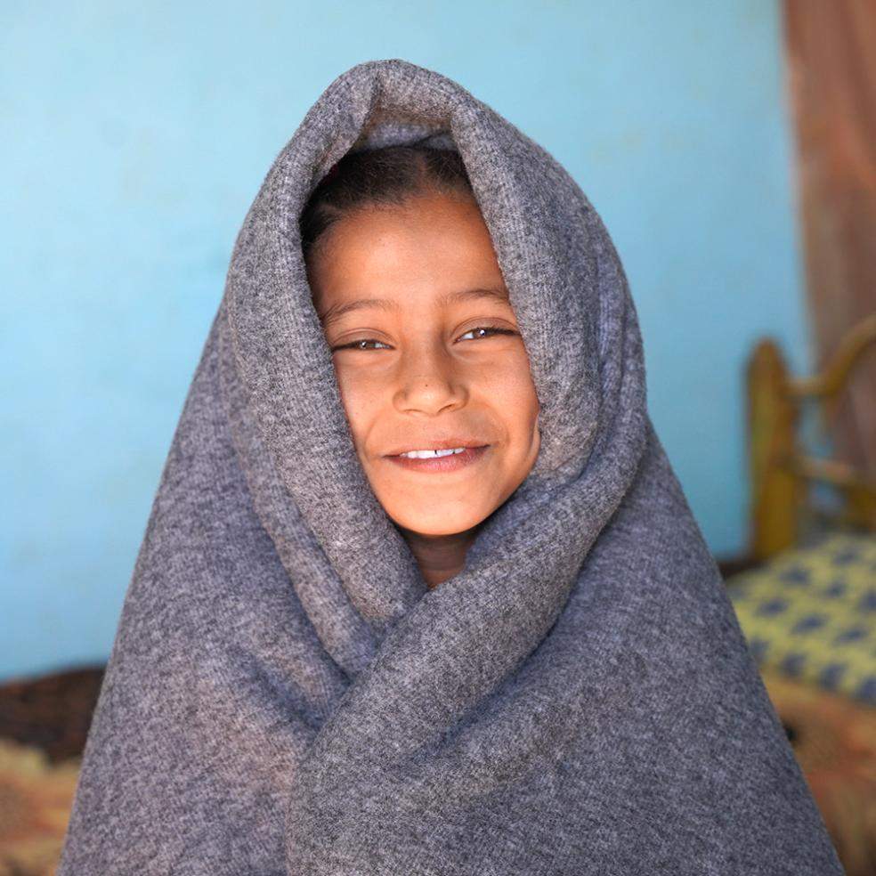 Ei jente er pakket inn i et pledd, Sudan