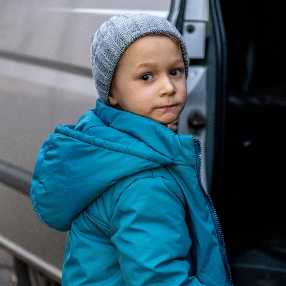 En gutt er på vei inn i en bil, Ukraina