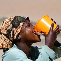 Dame drikker renset vann av plastkrus