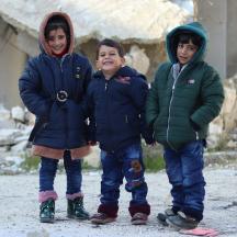 Tre barn med varme klær på seg